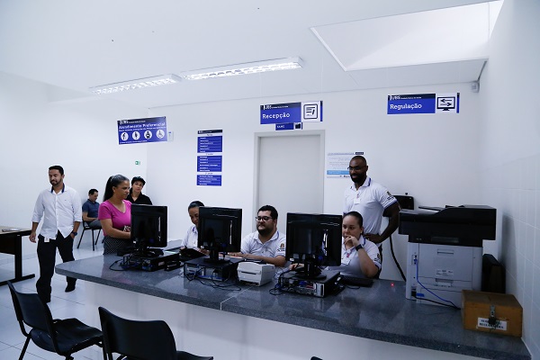#PraCegoVer: Fotografia do lado interno da nova UBS Vila Anastácio. Os novos funcionários estão sentados na recepção